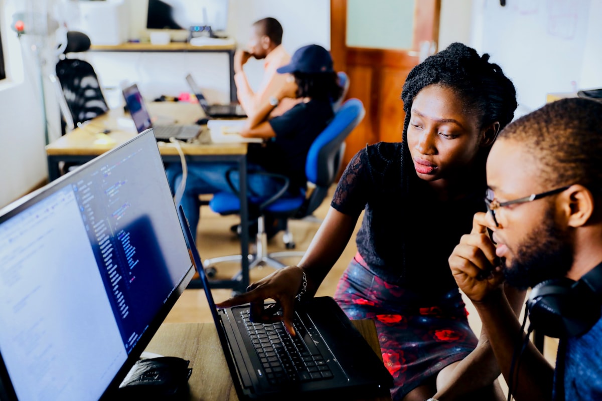 Two engineers working through code together at one screen